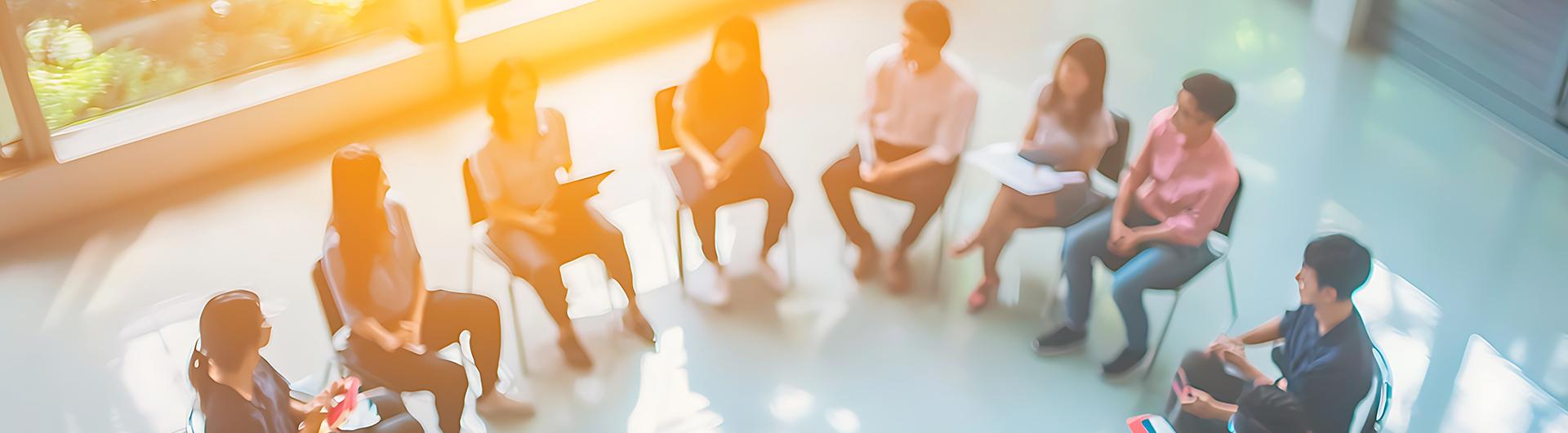 A group of people sitting in chairs arranged in an arc.