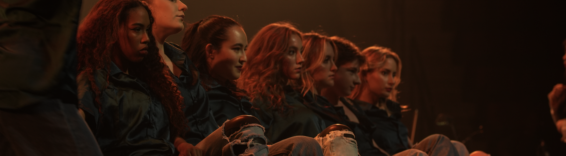 Dancers sitting in a line facing right