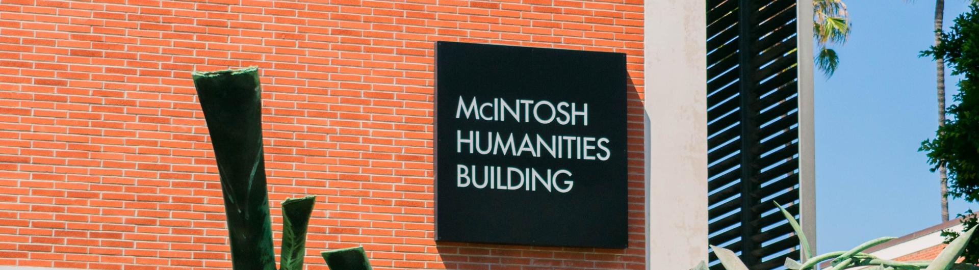 brick building with black sign that says "McIntosh Humanities Building"
