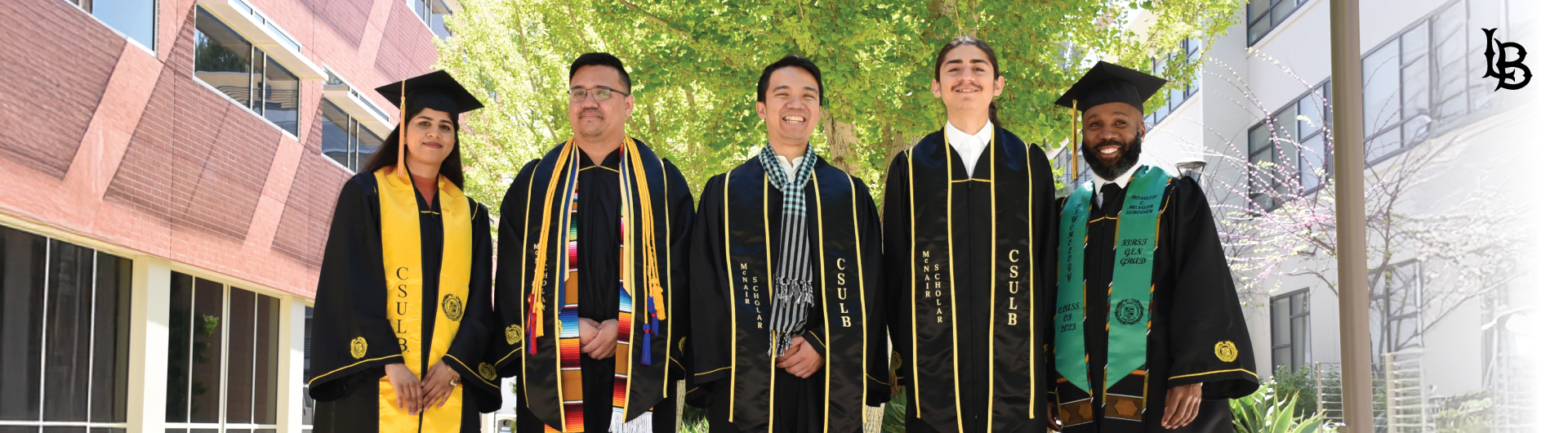 Group of five McNair students in their graduation cap and gowns.