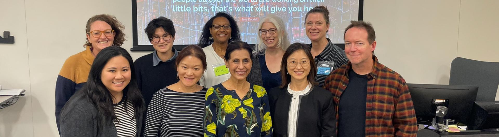 A group of people standing in front of a white board