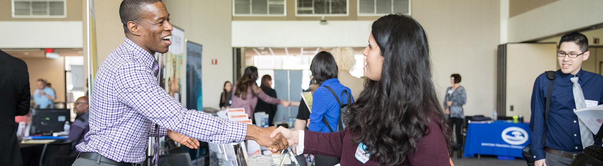 An employer and student shake hands