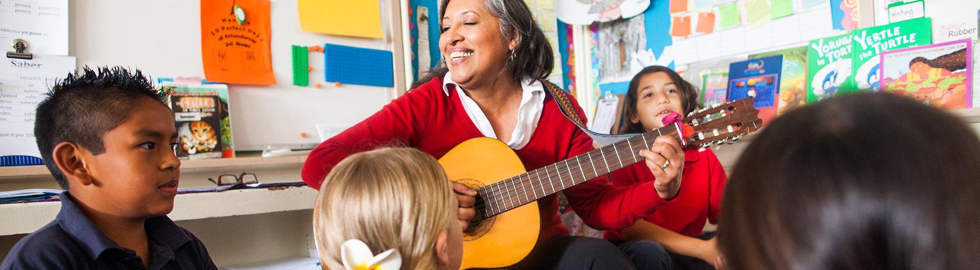 Teacher with a guitar in front of class