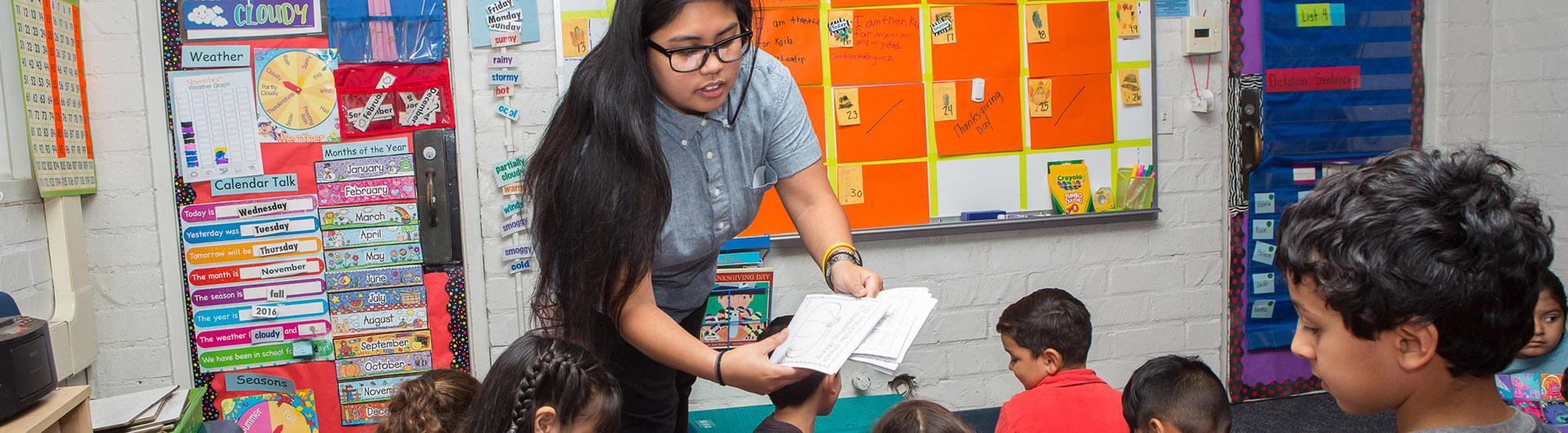 A teacher in front of an elementary classroom