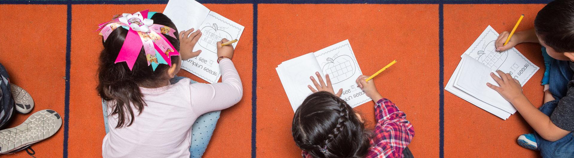 Children completing an assignment on the floor