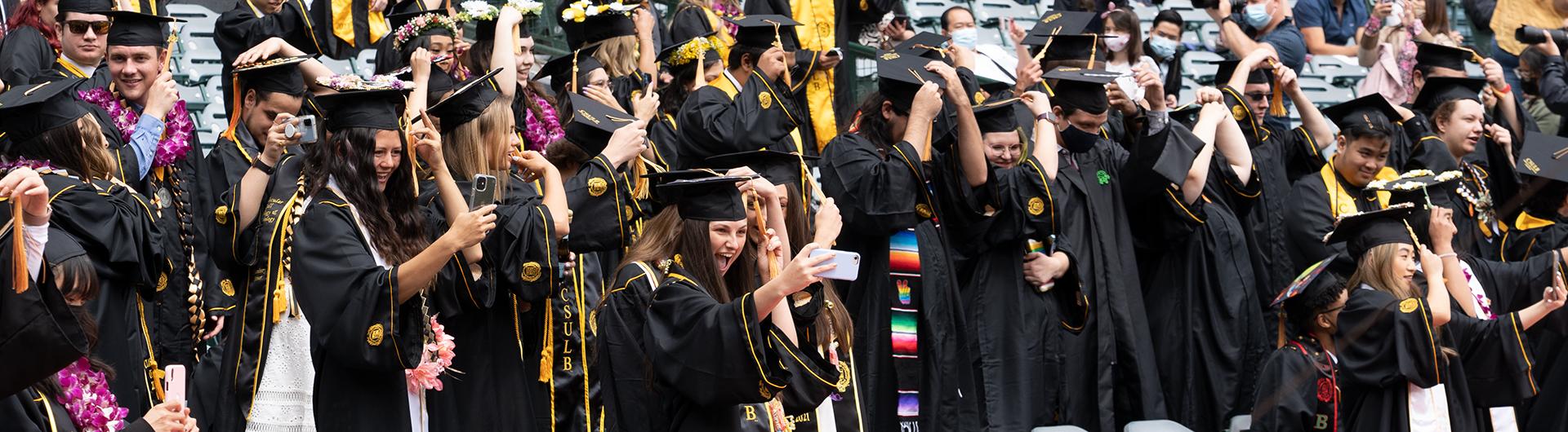 students in caps and robes celebrating graduation