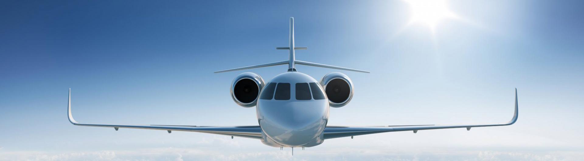 A jet plane with its head facing forward glides through clear blue skies.