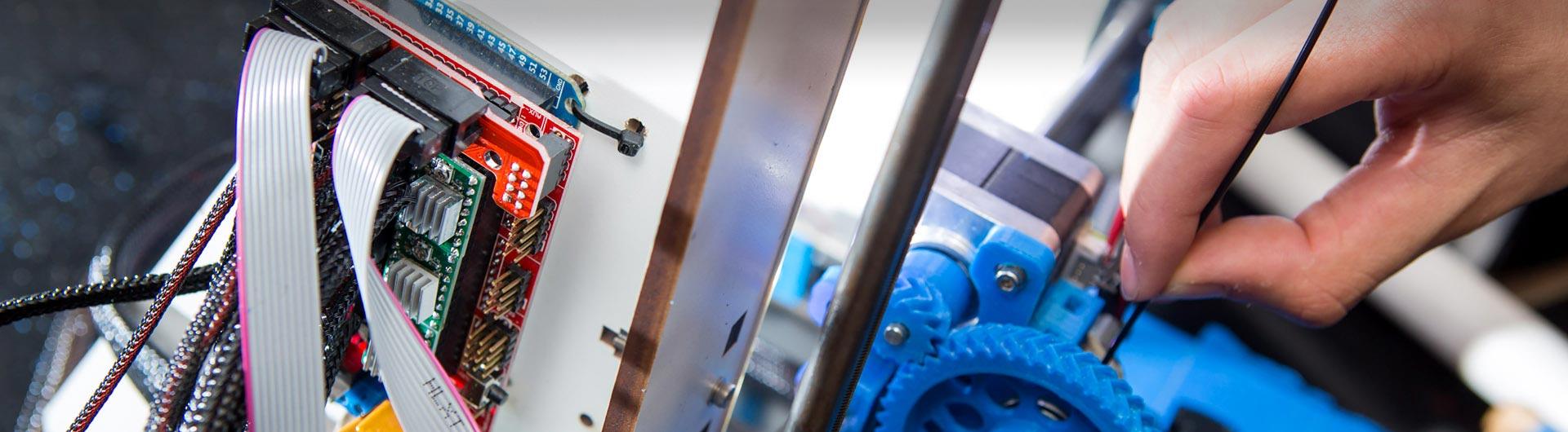 A person works on the interior of a machine