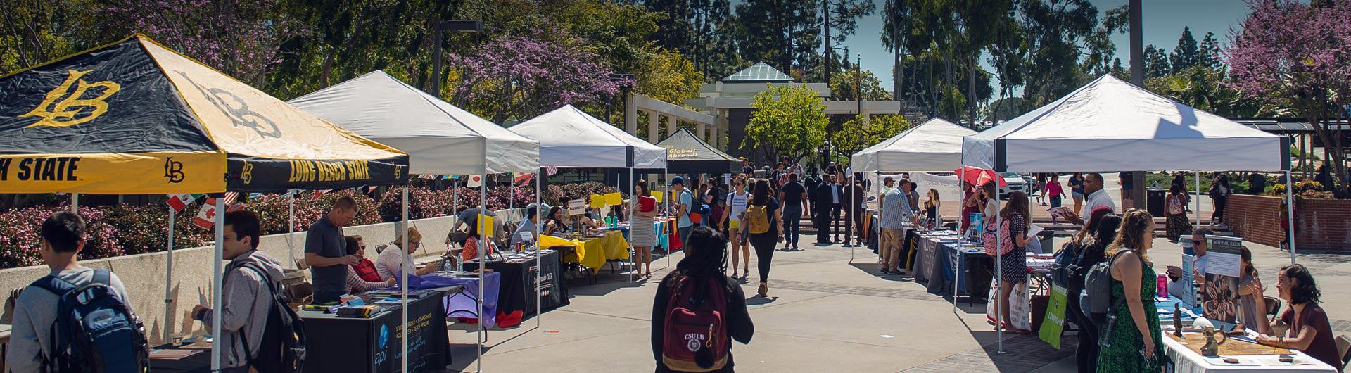 A student walks on campus at a job fair. 