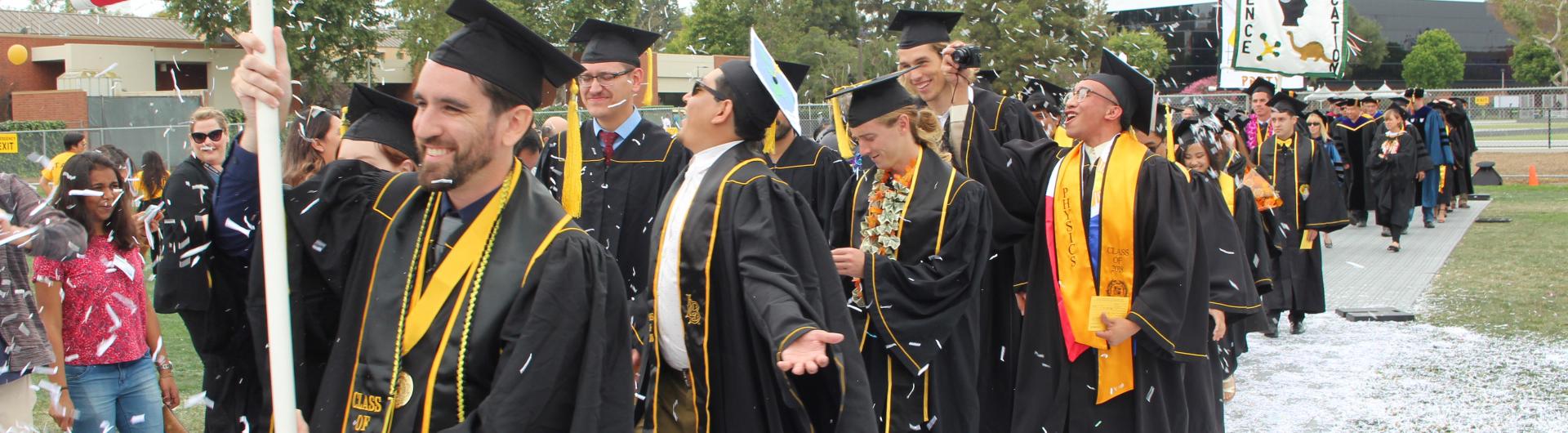 graduating students walking through confetti