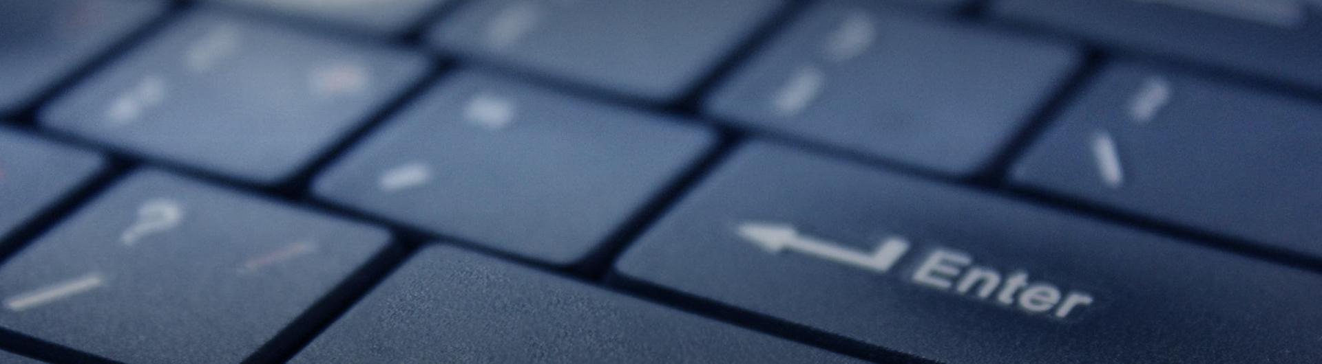 A close up of a keyboard focusing on the comma and enter buttons.