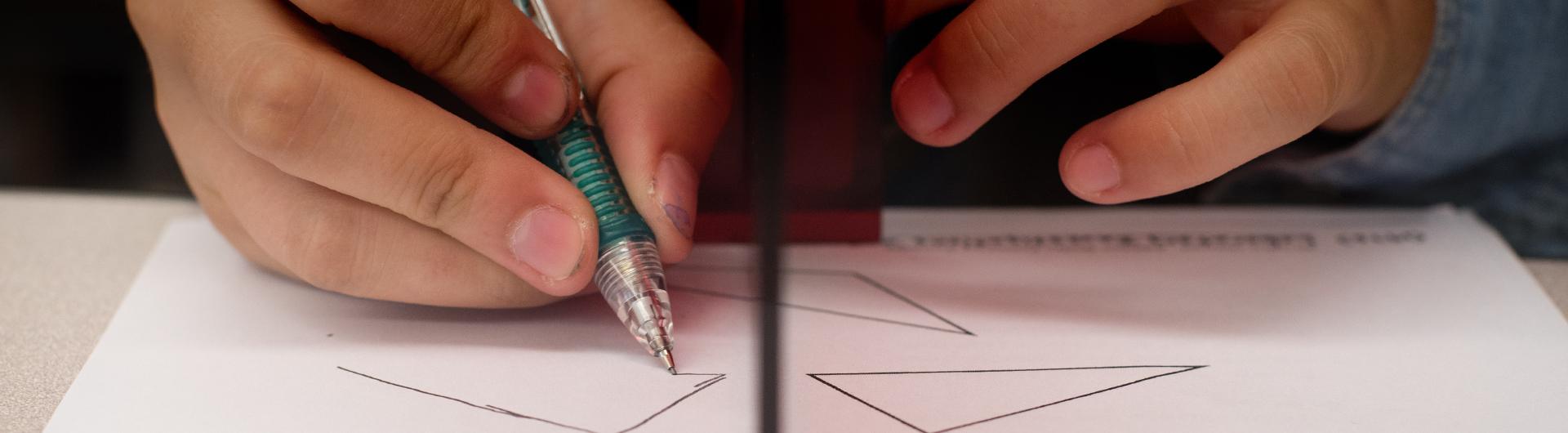 Student hands solving Math problme