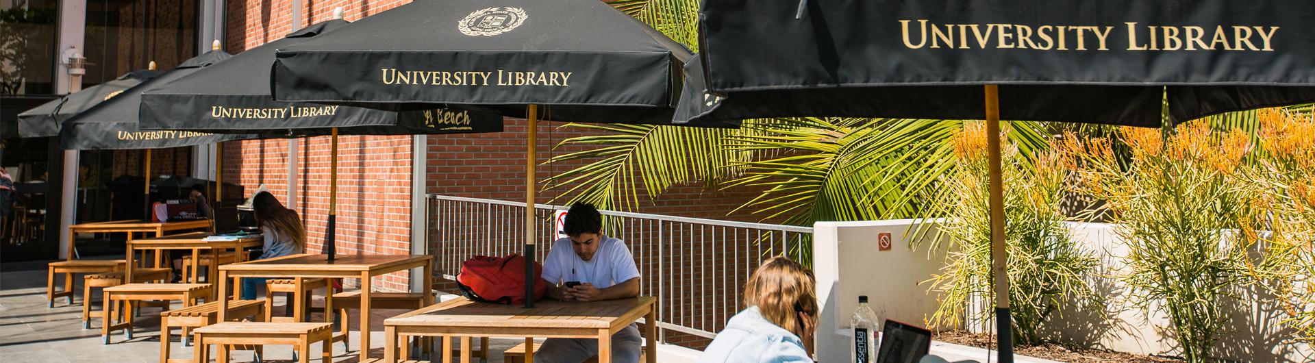 Students outside the University Library on benches