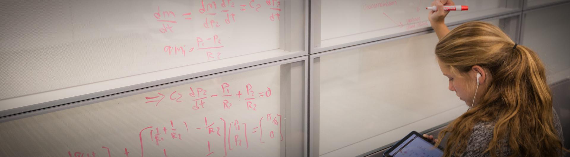 Student writes on a white board