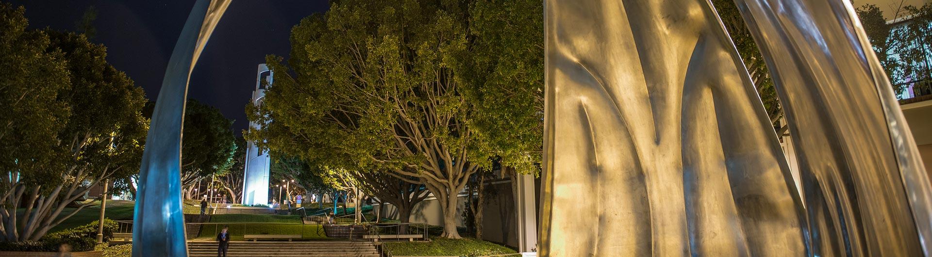 Campus at night near "Now" sculpture