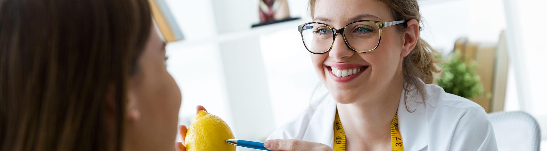 Dietician explaining to her patient the properties of the lemon during consultation