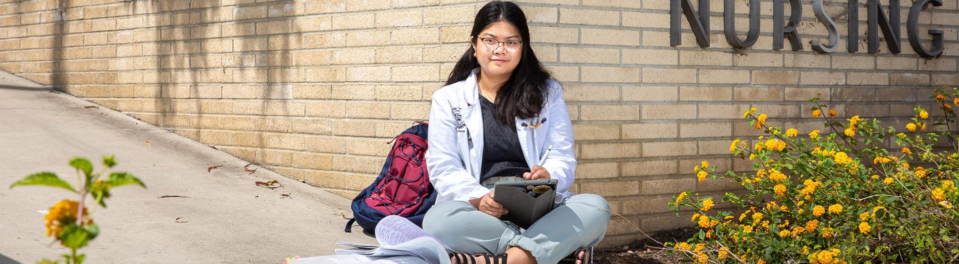 Elaine Araneta sitting in front of nursing building