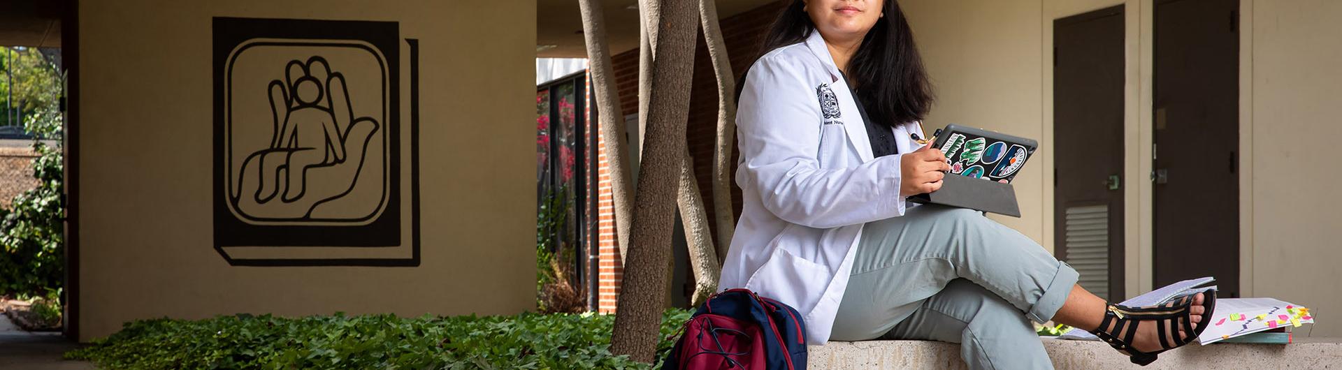 Nursing student Elaine Araneta sitting on concrete bench