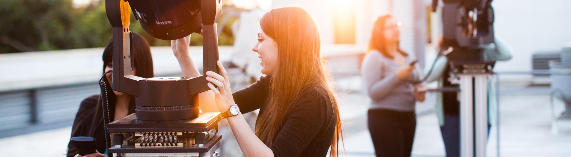 A student group looks through high powered telescopes