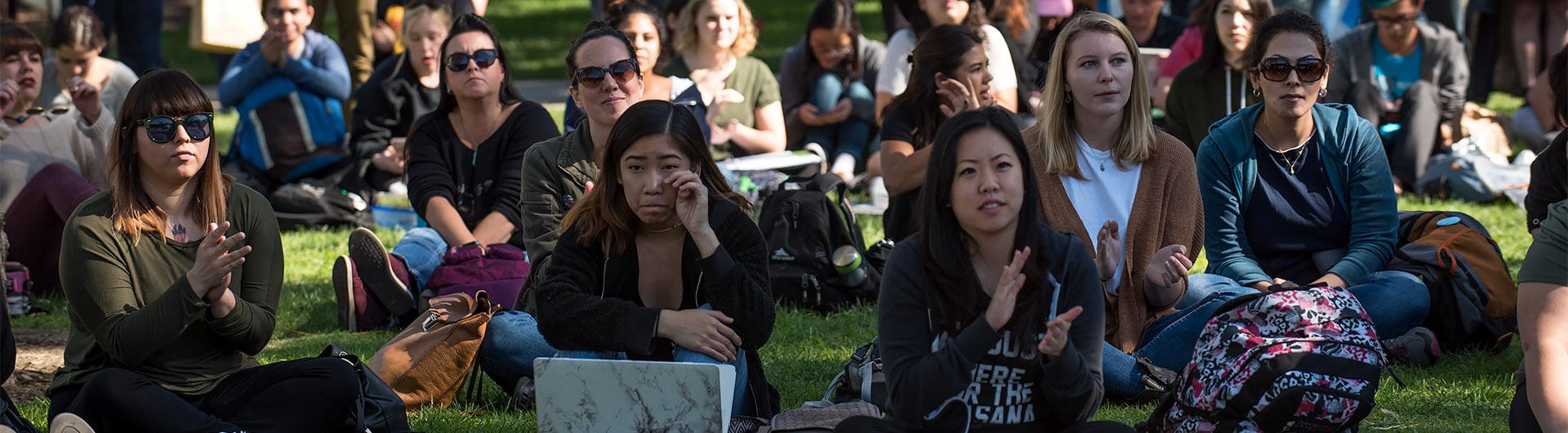 students sit in front of the speaker's platform