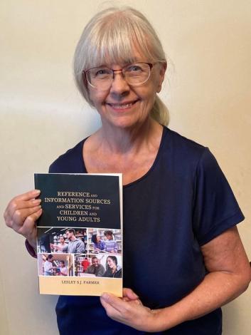Photo of a woman, Professor Lesley Farmer, holding a book