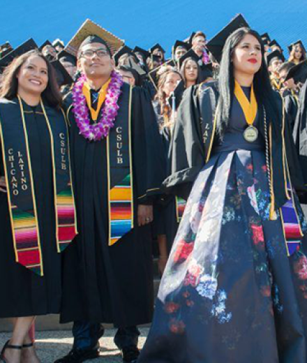 Students from the Chicano Latino grad ceremony standing in front of pyramid