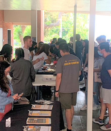 Students speaking and gathering in courtyard around tables