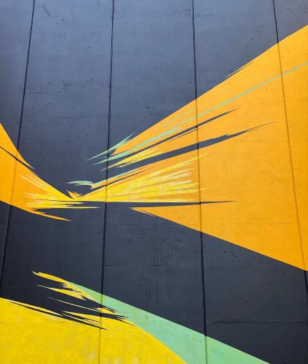 campus mural of yellow and green swathes on black