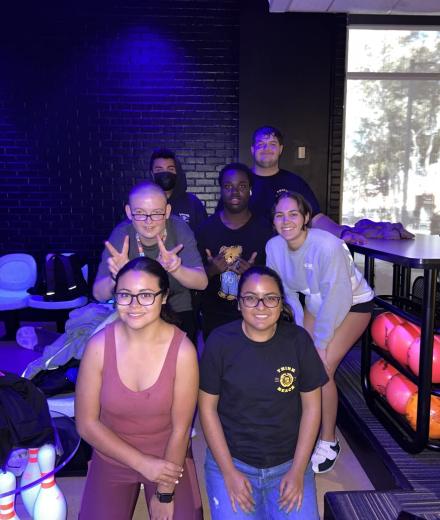 Students in Think Beach pose for a group photo at a bowling alley.