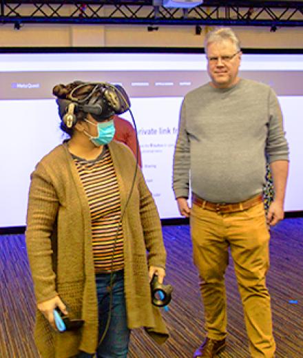 Stephen Adams poses with students using VR technology