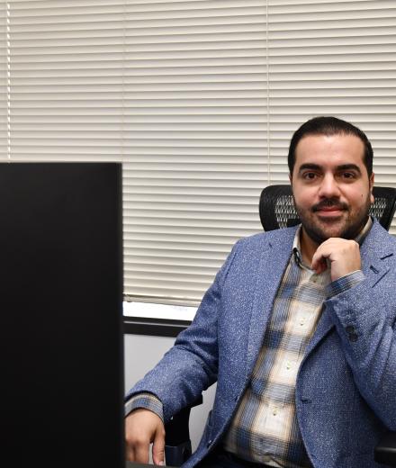 Amin Rezaei poses at desk