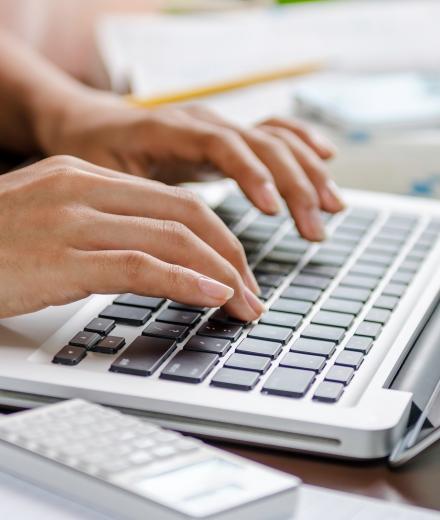 someone's hands typing on their computer