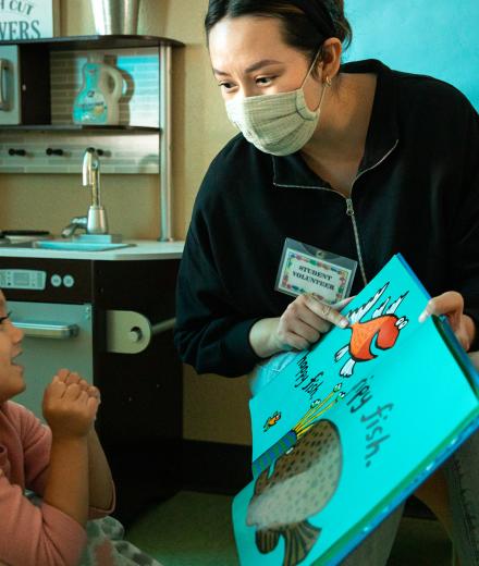 Teacher showing young student a book