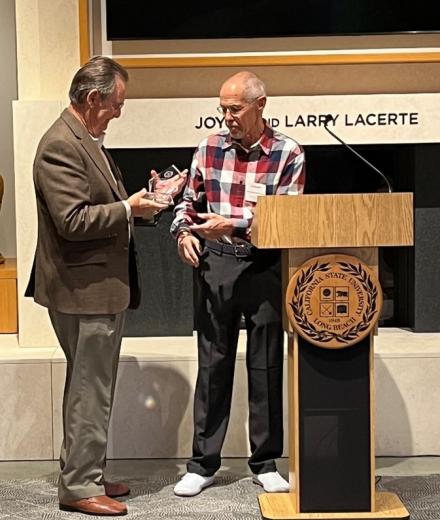 Dr. Rod Smith presenting the 2023 Outstanding MBA Alumni award to Robert Pitts.