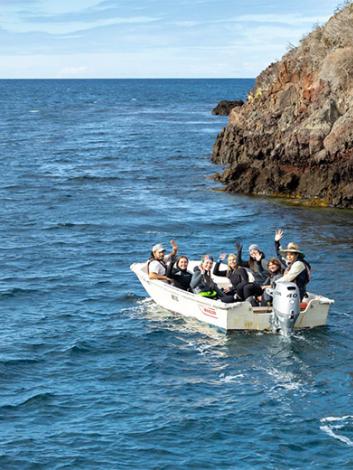 people in a boat waving goodbye