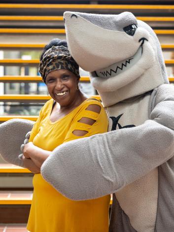 A staff member smiles with Elbee. 