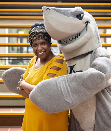 A staff member smiles with Elbee. 