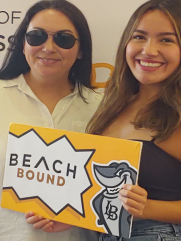 Two girls with Sign Beach Bound ant CSULB College of Business
