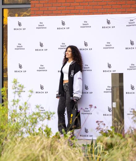 Girls stands in front of Beach XP Step and Repeat