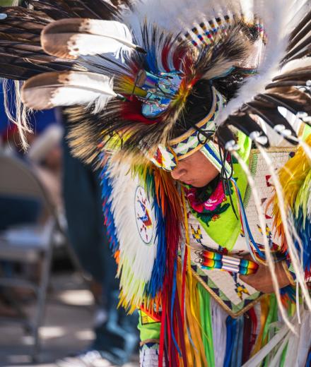 Culturally dressed Native American person bowing