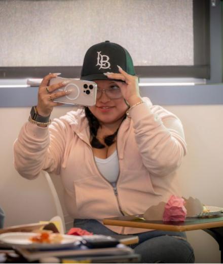 Student taking a selfie with Beach XP hat. 
