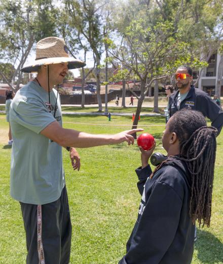 Instructor shows camper red shotput ball