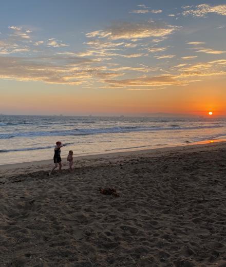2 people on the beach at sunset
