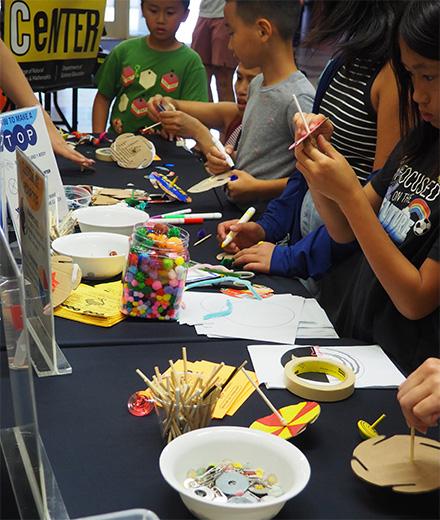 kids designing spinning tops from craft materials