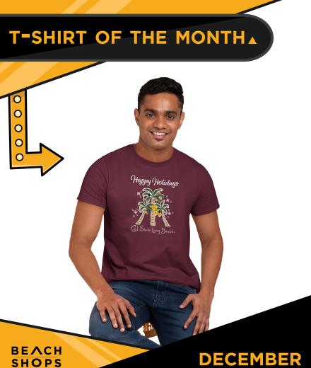 Man in a burgundy colored T Shirt with Happy Holidays from Cal State Long Beach on it and features three palm trees decorated like Christmas trees. 