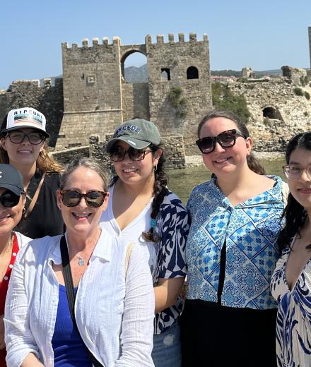 people in front of medieval castle by water