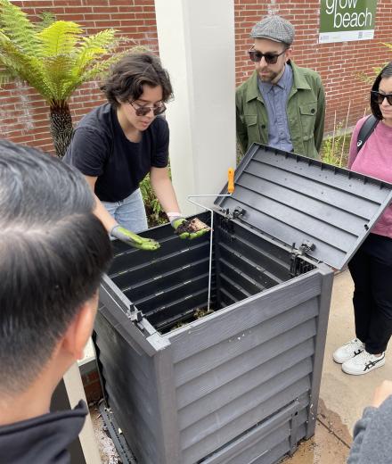 People in the Grow Beach Garden looking at a compost bin