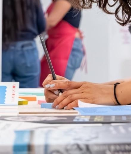 a hand writing on a piece of blue paper