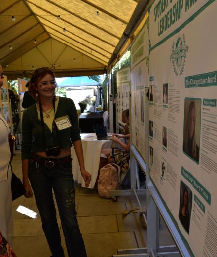 Three students standing in front of a board looking at a poster.