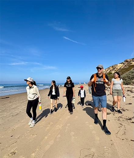 students and mentors walking along beach